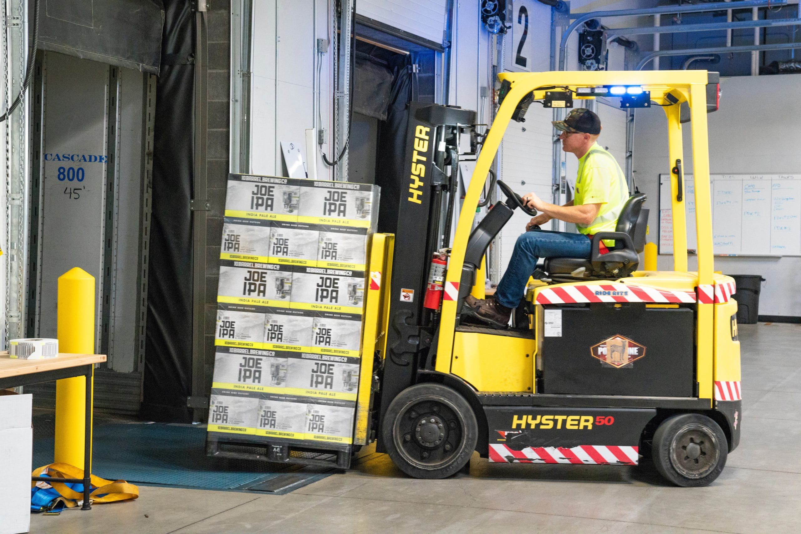 Warehouse operative on forklift moving palletised boxed goods representing Plexus Freight's palletised cargo handling