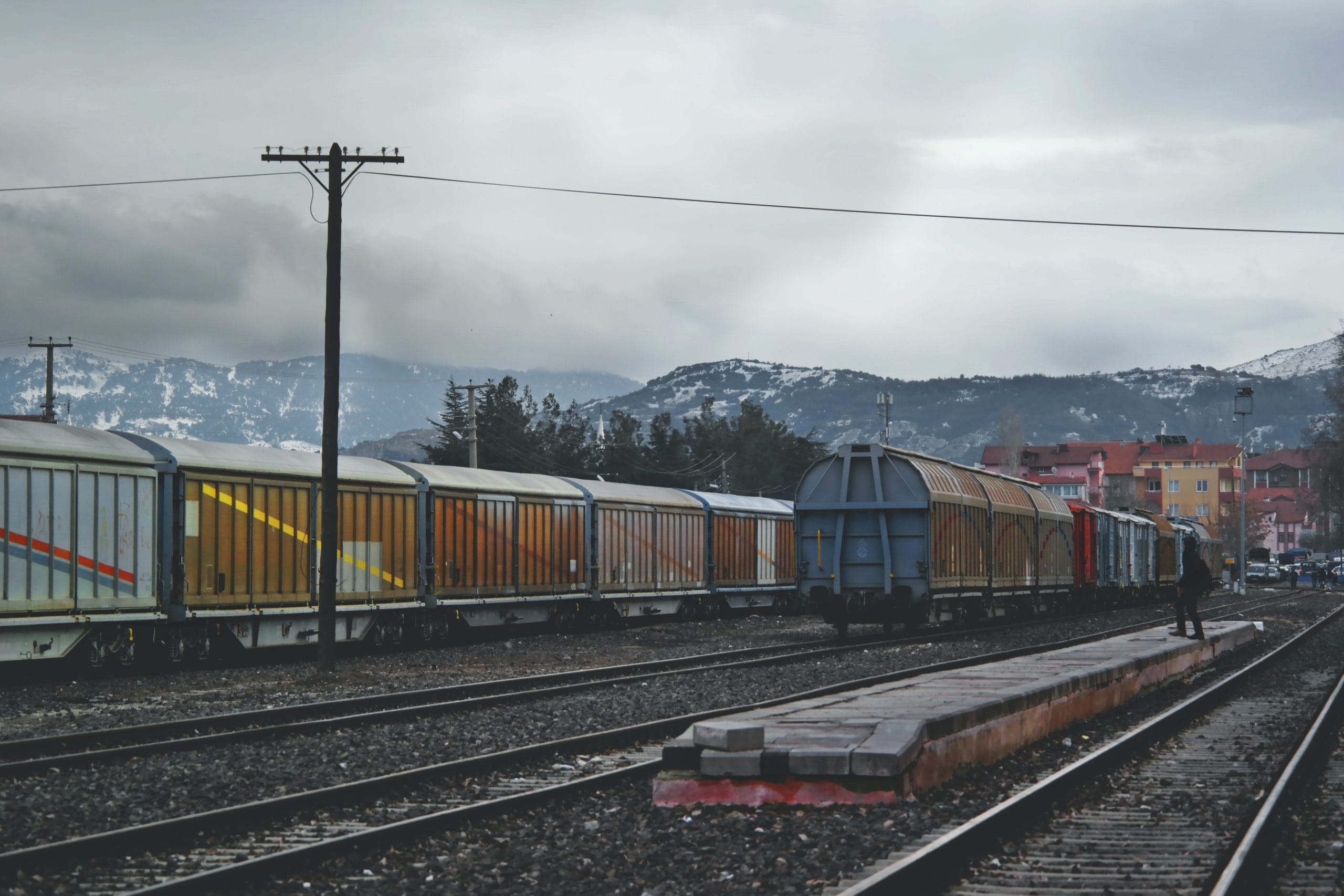 Freight wagons on a rail line with snow-capped mountains representing Plexus Freight's rail freight services