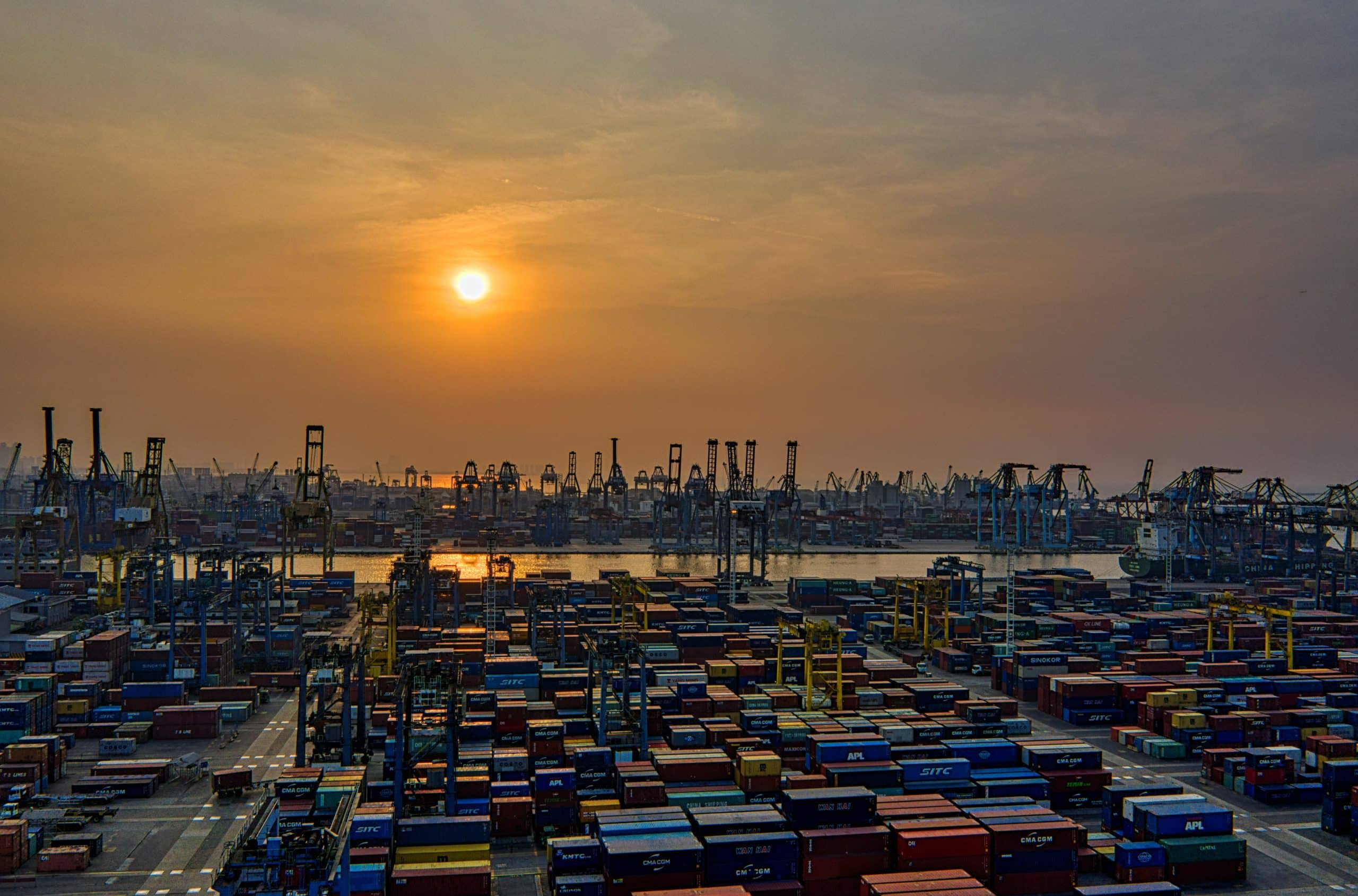 Aerial view of busy container port terminal at sunset representing Plexus Freight's sea freight operation