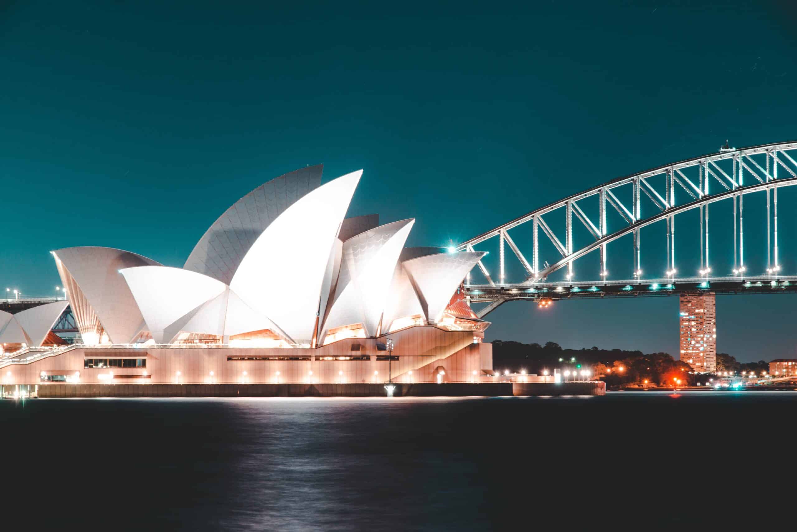 Sydney Opera House and Harbour Bridge illuminated at night reflected on the water