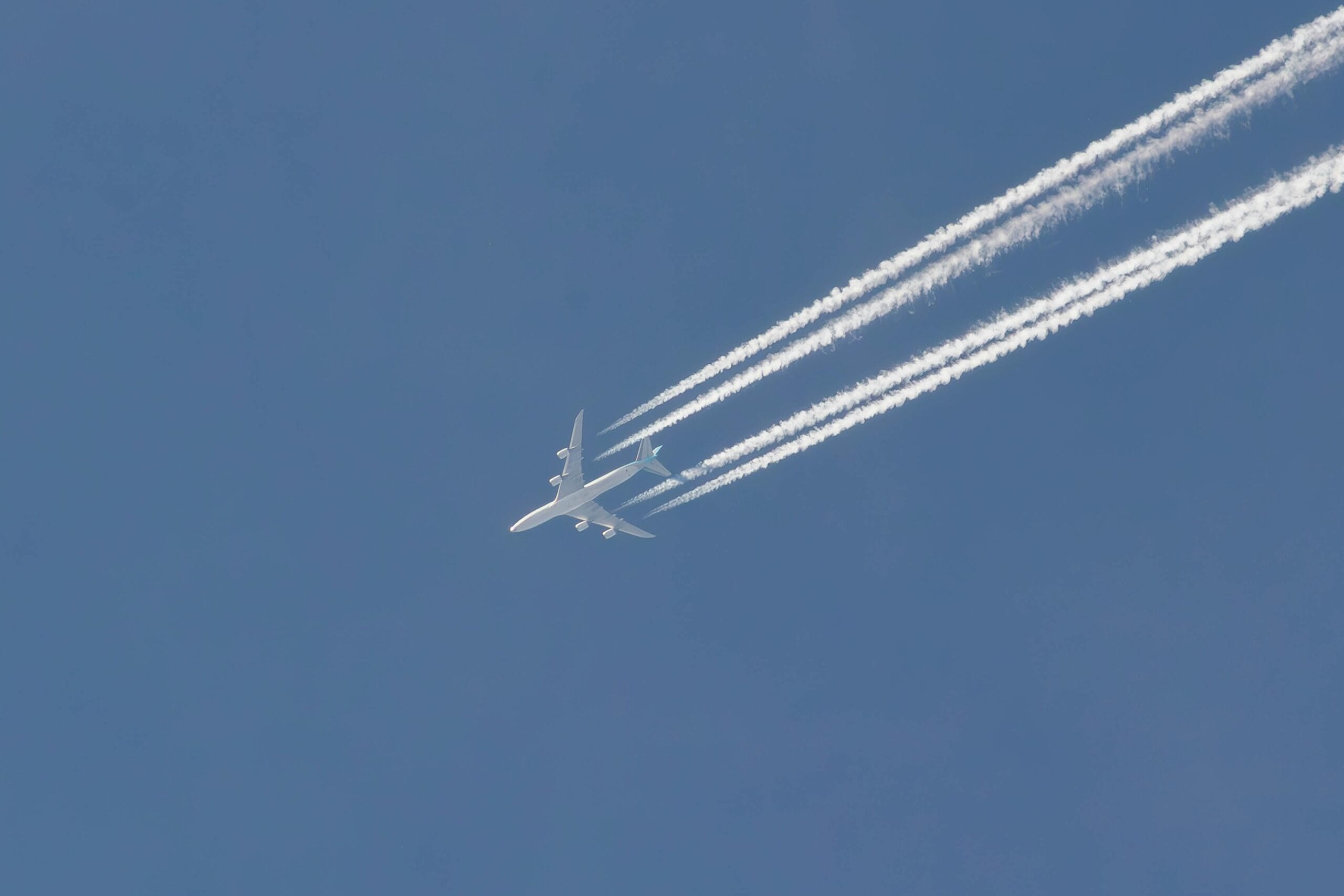 Cargo aircraft in clear blue sky with contrails representing Plexus Freight's international air freight services