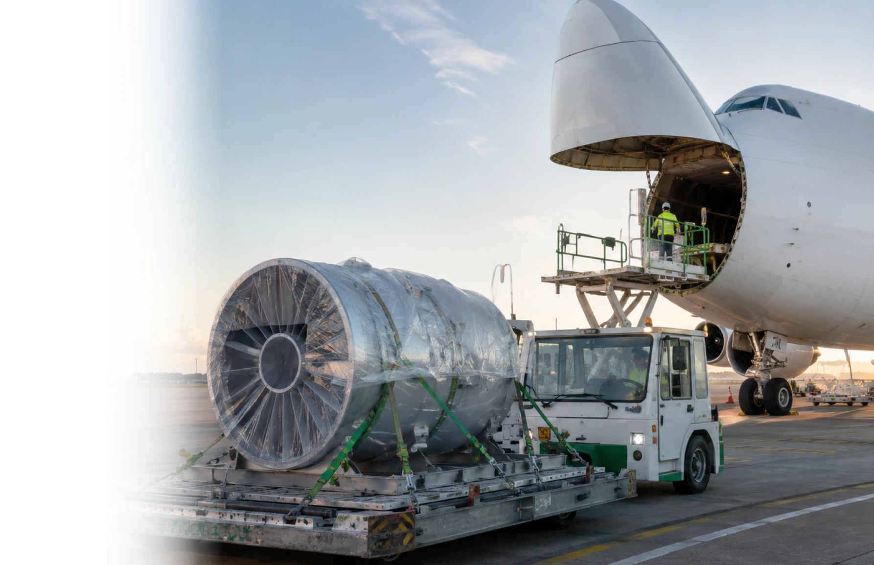 Jet engine being loaded onto cargo aircraft at airport representing Plexus Freight's out-of-gauge air freight services
